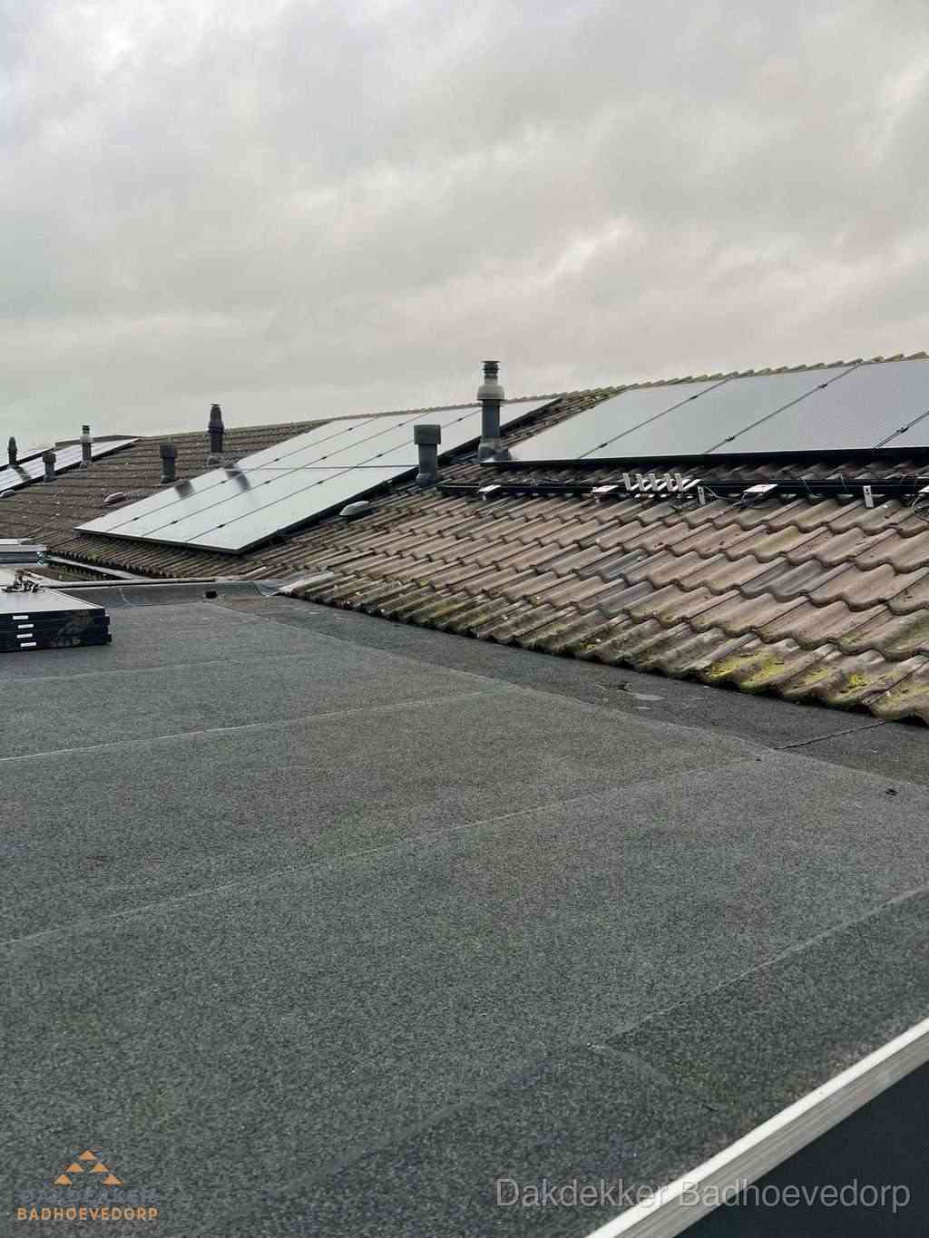 Bitumen dakbedekking op plat dak met aansluitend pannendak en zonnepanelen in Badhoevedorp