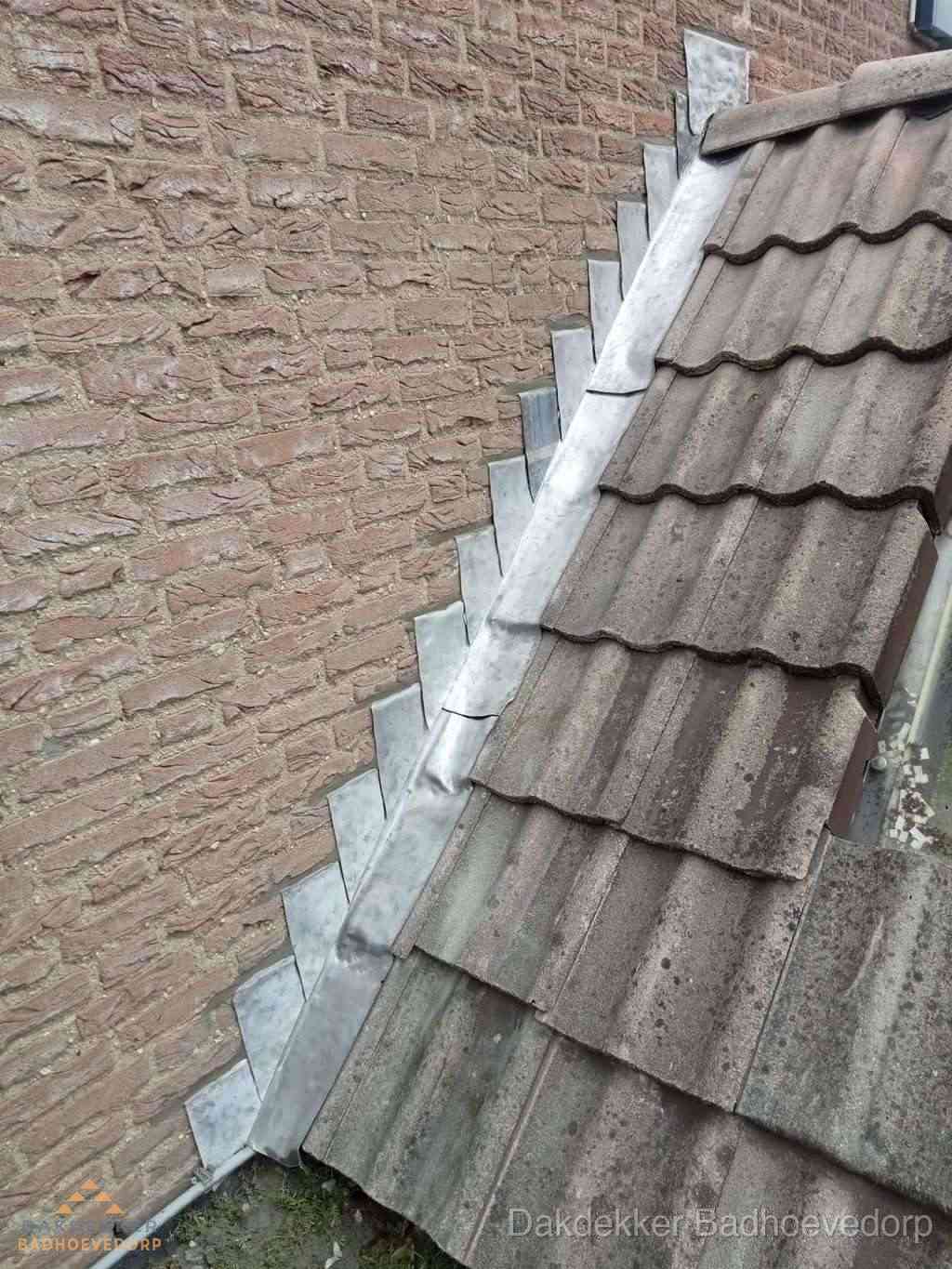 Loodslabben langs dakaansluiting bij bakstenen muur in Badhoevedorp